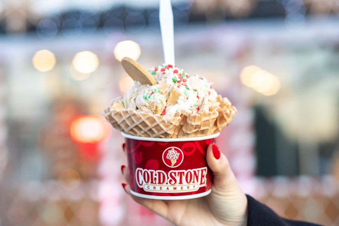 holding a cup of ice cream with a waffle cone